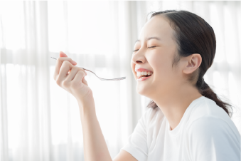 女性が笑いながら楽しのうに食事をしている画像